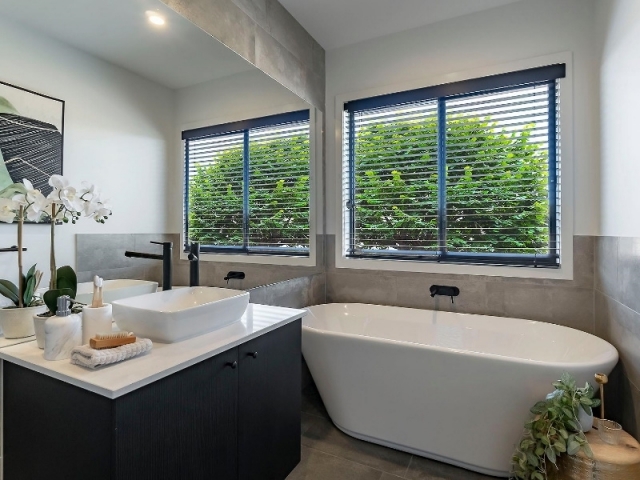 Finca Kinchington - El baño cómodo y elegante con pared espejada y bañera.