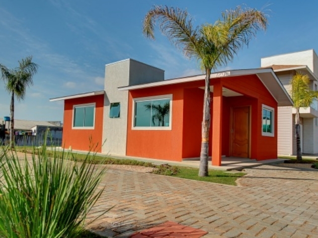 Casa de 54 m2 con 2 dormitorios (Steel Frame) en Brasil - Vivienda terminada en color naranja con ventanas vidriadas.