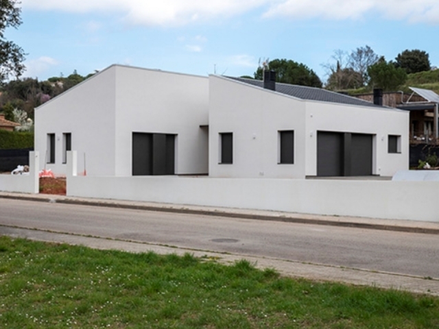 Elicsia Singular entrega una nueva casa prefabricada - La casa de Elicsia pintada en blanco con aberturas en gris.
